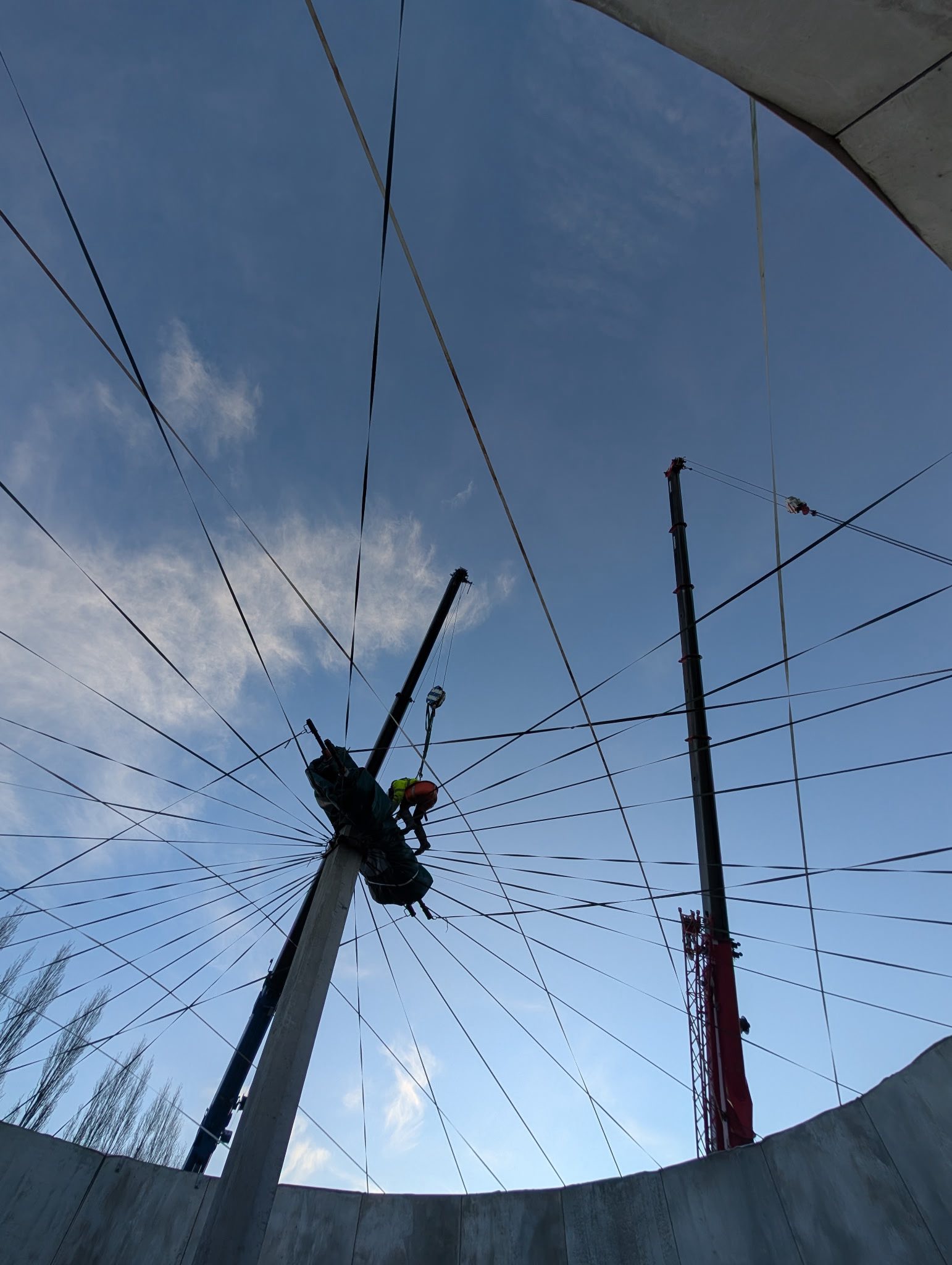 Two crane lift in progress during fibre roof installation on a Bristol biogas tank