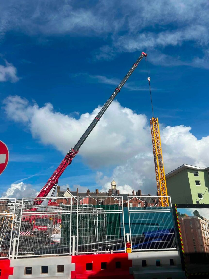 Demag AC100/4L mobile crane lifting tower crane section during erection in the South West